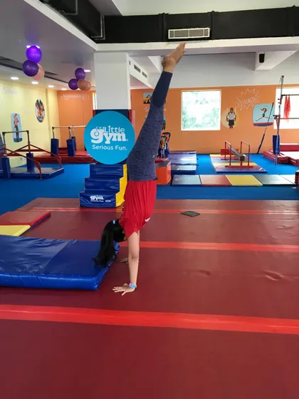 This student demonstrates a beautiful split handstand, a more advanced variation that requires significant flexibility and balance. It's a fantastic display of athletic skill.