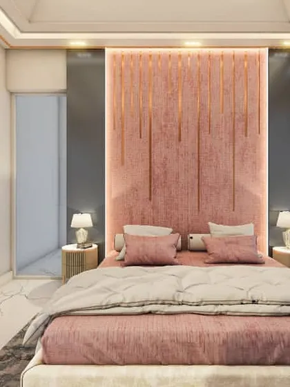 This bedroom features a soft pink, floor-to-ceiling upholstered headboard with integrated lighting. The color palette of pink, grey, and teal creates a calm and contemporary feel, perfect for a modern home.