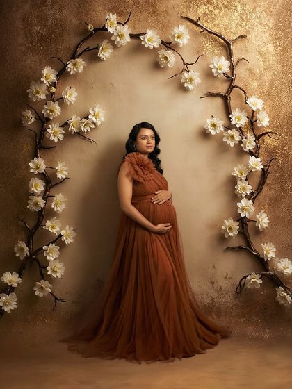 A solo portrait in our Copper gown. The floral arch in our studio creates a beautiful frame for this elegant and earthy-toned dress.
