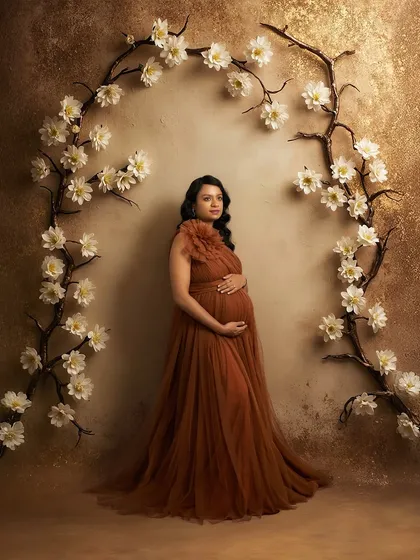 A solo portrait in our Copper gown. The floral arch in our studio creates a beautiful frame for this elegant and earthy-toned dress.