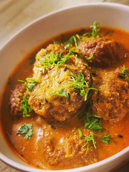 A close-up of the soft lauki koftas soaking up the delicious, spicy curry. This dish is perfect with roti or rice.