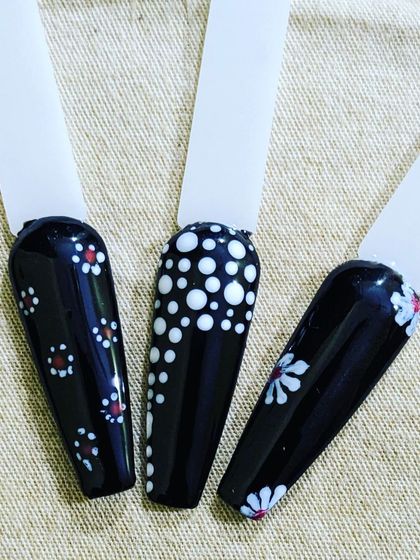 A closer look at some design ideas on a black gel polish base. The high contrast makes white and red dot work and floral patterns really pop.