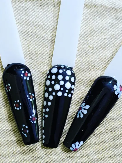A closer look at some design ideas on a black gel polish base. The high contrast makes white and red dot work and floral patterns really pop.