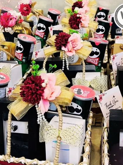 A glimpse into a large order of wedding favors. Each basket is carefully curated with snacks and gifts, adorned with floral arrangements and pearl strings to thank guests for their presence.