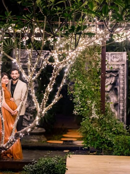The trees wrapped in fairy lights create a whimsical forest effect, perfect for capturing wide shots that showcase the enchanting ambiance of the entire location at night.