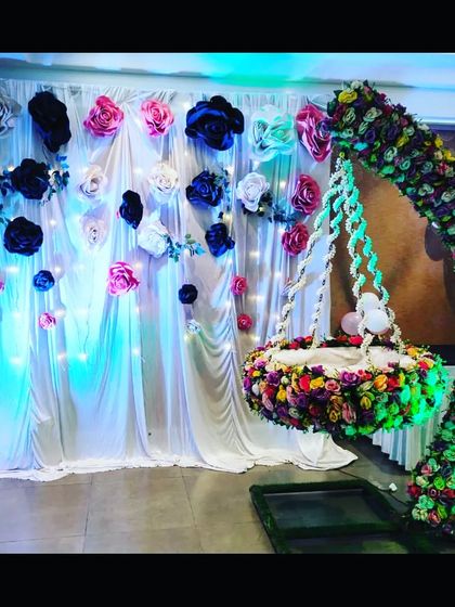 The naming ceremony setup with blue-green lighting, giving the floral arrangement a cool and magical glow.
