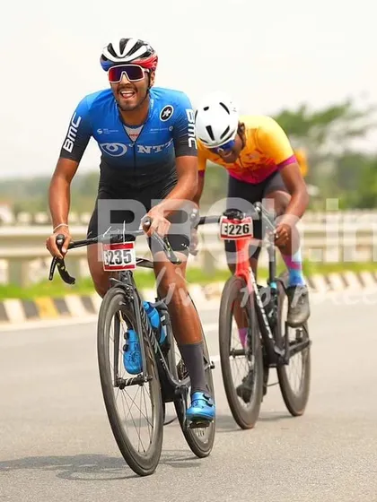 Two elite riders, one from the BMC racing team, share a smile during the race.