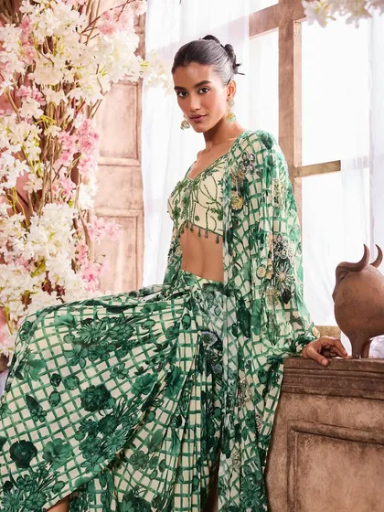 A solo shot featuring a green printed lehenga. The makeup is fresh and radiant, with a soft brown eye and a nude lip to balance the detailed outfit.