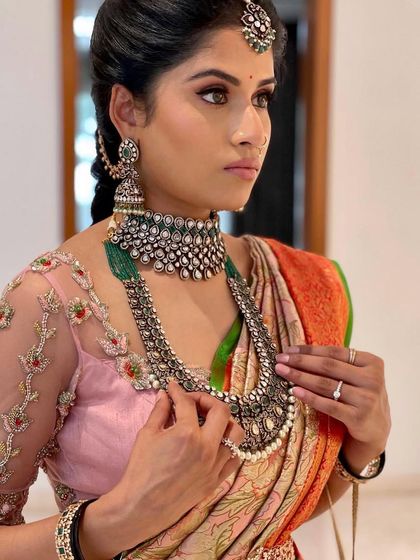 Adjusting her stunning necklace. This candid shot shows the makeup in action, looking flawless and natural.