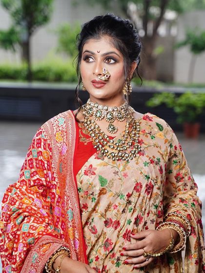 A front view of the messy khopa, showing how the soft tendrils frame the face beautifully. This style is perfect for a bride who wants an updo that feels soft and romantic rather than severe.