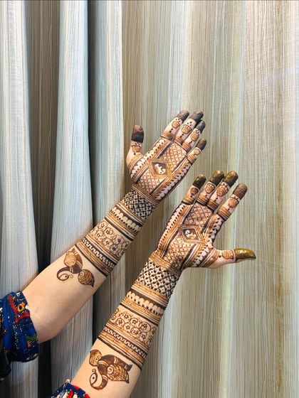A semi-bridal design with a mix of patterns, including elephants on the upper arm.