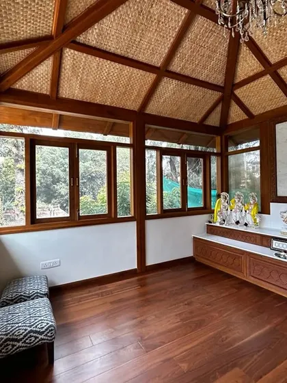 This sacred temple space was designed as a peaceful sanctuary within the home. The wooden structure and flooring, combined with a thatched ceiling, create a natural and serene atmosphere.