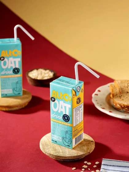 A playful studio shot of Alt Co.'s oat milk cartons against a color-blocked background. The clean lines and bright colors give the image a modern and graphic feel.