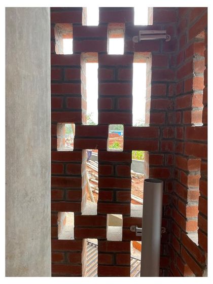 A close-up of the perforated brickwork, or "jali," during construction. This detail is crucial for natural ventilation.