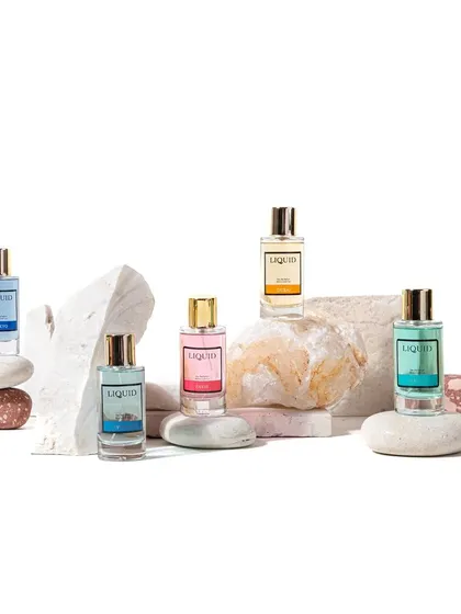 A group shot of a perfume collection, styled on natural stones of varying colors and textures. This setup highlights the full range of scents while maintaining a cohesive, earthy, and elegant look for a website banner.
