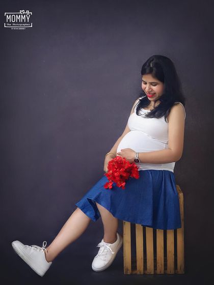 A cute and casual solo portrait in the studio. The simple outfit of a tank top and denim skirt shows off the baby bump beautifully and has a fun, relaxed vibe.