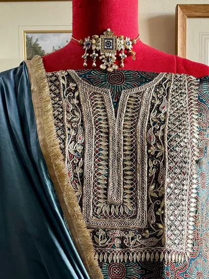 We present a handcrafted modal silk kurta featuring a yoke heavily embroidered with Gota Patti and Marodi work. It is paired with a solid Italian silk organza dupatta with complementary embroidery.