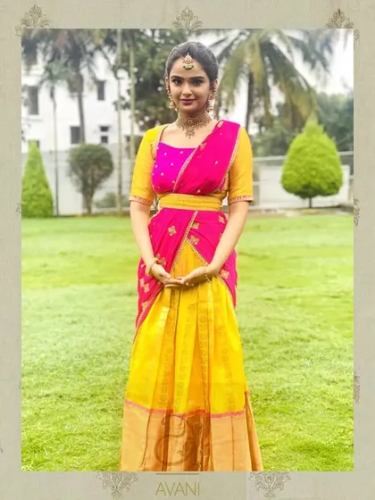A client in a bright yellow and pink half-saree. The simple, elegant design is perfect for pre-wedding ceremonies and festive occasions.