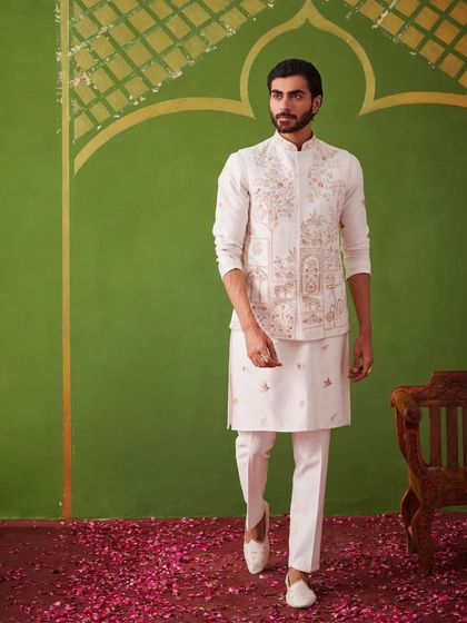 The model walks towards the camera in the white kurta set, showcasing the movement and flow of the outfit. It's a look that is both graceful and commanding.