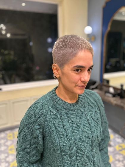 A full view of a fresh buzz cut with a soft, silvery-ash color. This is the ultimate power cut, proving that short hair has infinite possibilities.