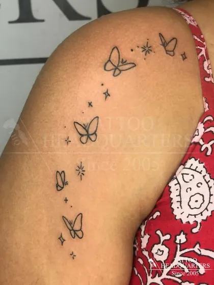 Sometimes, less is more. We love creating delicate and minimalist tattoos, like this trail of fine-line butterflies on the shoulder, for a subtle yet beautiful look.