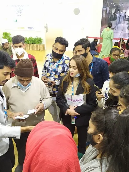 Performing a card trick for interested visitors at a trade show booth. This is a great way to initiate conversations and draw potential clients in for a demonstration.
