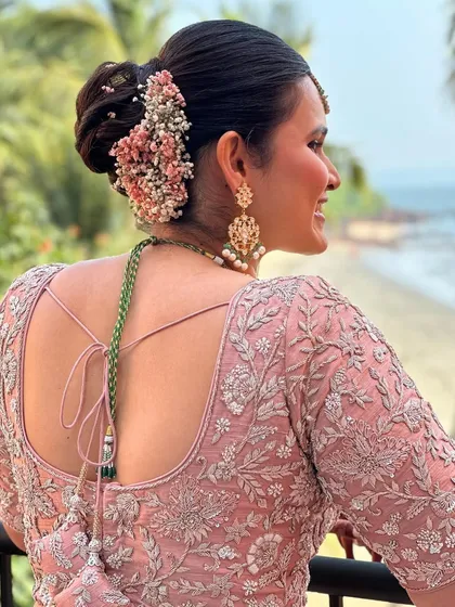 A beautiful bridal bun for a beach wedding. I used a mix of baby's breath and delicate pink flowers to create a soft, romantic look that suited the seaside setting.
