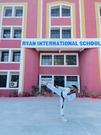 A powerful side kick in front of Ryan International School, one of the schools where we provide training.