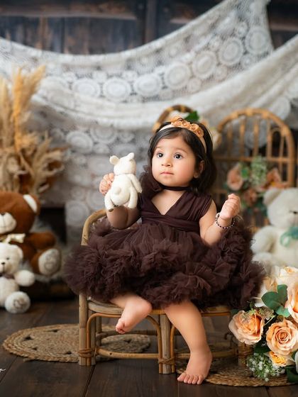 A sweet baby girl in a brown tulle dress, posing with her little teddy bear. I use simple props to keep the focus on your baby's adorable personality.