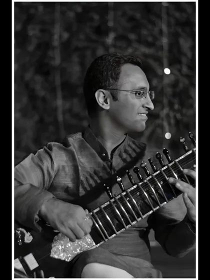 A black and white shot from an evening performance, with beautiful bokeh lights in the background.