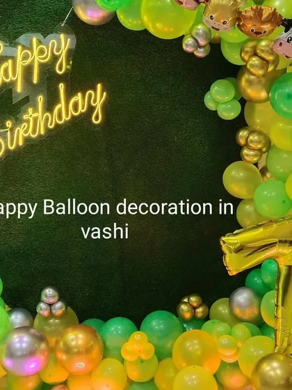 A close-up of the animal-themed birthday backdrop, featuring a green wall, neon sign, and animal foil balloons.