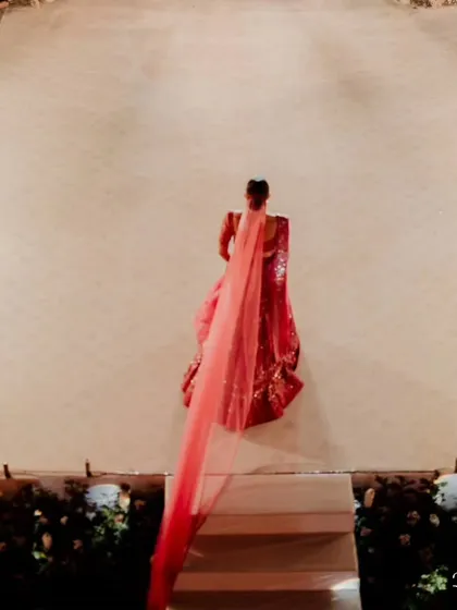 An aerial view of the bride's walk down a long, dramatic aisle lined with pyrotechnics. Her long veil trails behind her, creating a truly iconic and unforgettable image of bridal elegance.