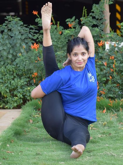 Practicing outdoors, a student holds a beautiful standing split variation. Connecting with nature enhances the focus and grounding needed for such balancing poses.