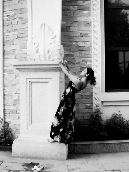 A black and white series exploring different poses against architectural elements. These shots focus on form, light, and the interaction between the subject and her environment.