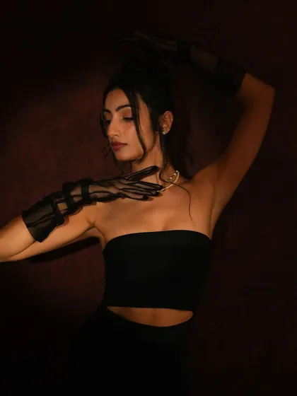 A dramatic pose from a vintage-themed shoot. The lighting highlights the contours of the face, and the makeup is designed to be both sultry and sophisticated.