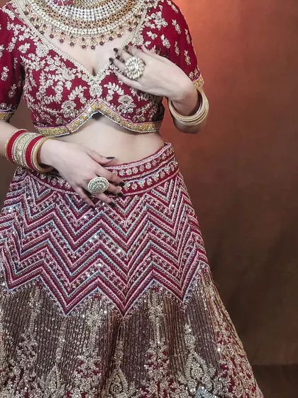 A closer look at the detailed embroidery on the chevron-patterned maroon lehenga. You can see the quality of the zari and sequin work.