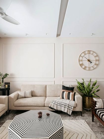 This shot highlights the geometric, black and white coffee table, which acts as the centerpiece of the living room. It's a bold choice that anchors the space and ties together the various seating elements.