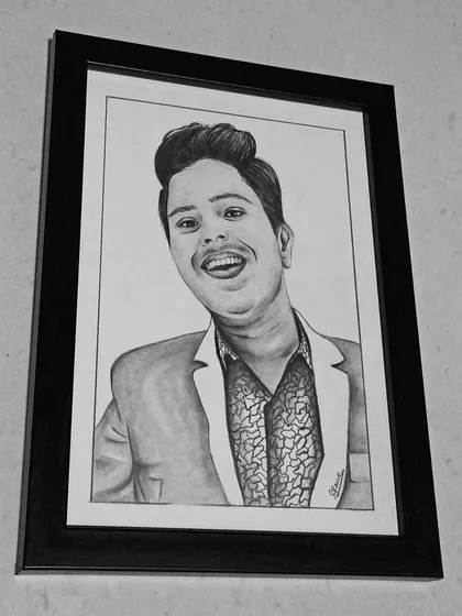 The final product, ready to be displayed. This is a completed A5 pencil portrait, professionally framed in a classic black frame, making it a perfect, ready-to-hang gift for a loved one.
