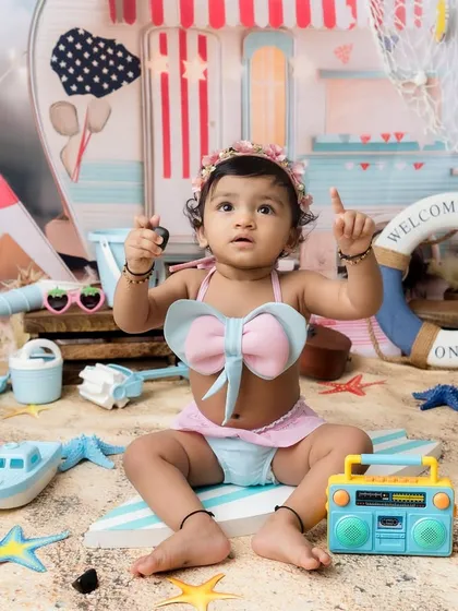 Pointing up at the "sky" in this adorable beach-themed studio setup.