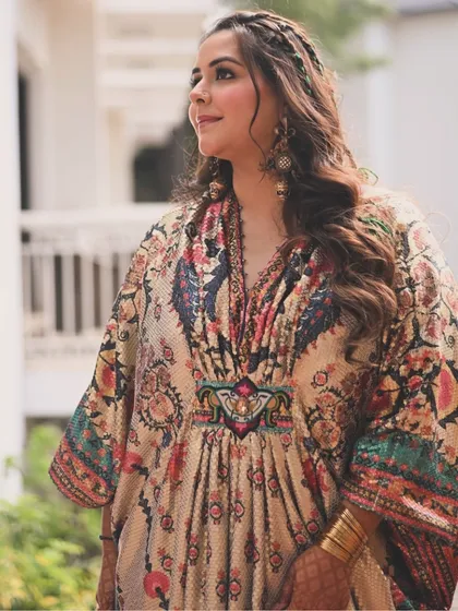 Another look at the elegant kaftan, a perfect choice for a modern bride who values both style and comfort. The braided hairstyle with green wool accents added a playful, bohemian touch to the ensemble.