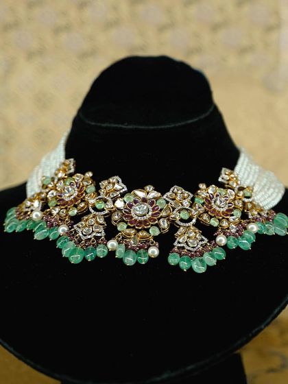 This floral-inspired polki choker with cascading emerald beads is a perfect example of modern bridal jewellery, blending traditional uncut diamonds with a contemporary design.