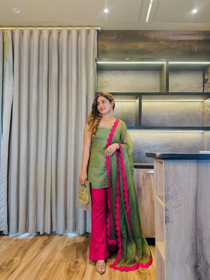 This olive green and fuchsia suit is a perfect example of custom styling. The bold fuchsia scallop detail on the organza dupatta makes the entire outfit stand out without screaming for attention.