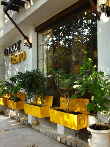 Bright yellow planters add a pop of color to the exterior of Amour Bistro. This simple, cheerful detail contributes to the restaurant's welcoming and approachable character.