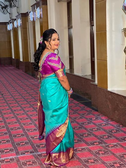 A side view of Swathi's reception look, showing her soft, curly hairstyle and the beautiful drape of her silk saree.