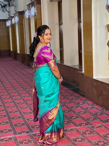 A side view of Swathi's reception look, showing her soft, curly hairstyle and the beautiful drape of her silk saree.
