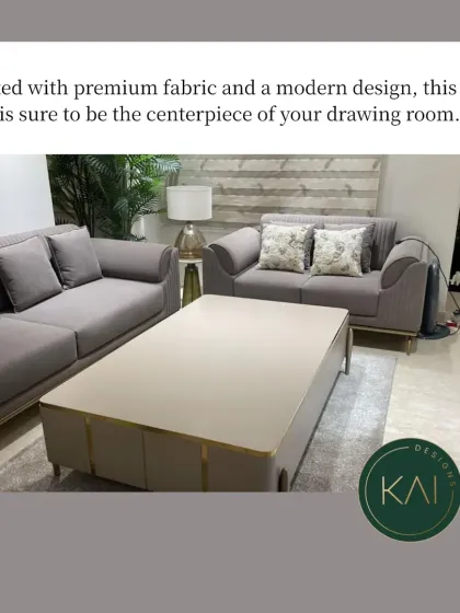 A modern living room we furnished, featuring a sleek grey sofa set with clean lines and subtle metallic leg details. The large, light-toned coffee table with gold accents complements the seating, providing a functional and elegant centerpiece.
