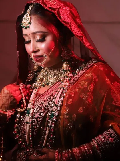 A full view of the bride's stunning ensemble. The makeup is designed to harmonize with the rich colors and intricate details of her outfit.