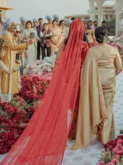 The bride's breathtaking walk down the aisle, with a long, beautiful veil and the groom waiting expectantly.