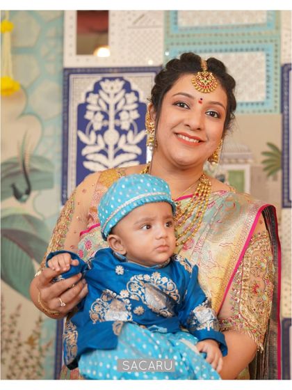 A beautiful portrait of our client Bhavna and her baby, both in custom outfits, showcasing the joy of the occasion.