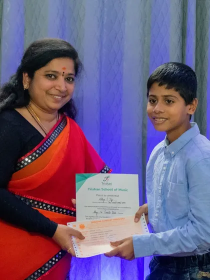A student is awarded his certificate of completion for his music grade.
